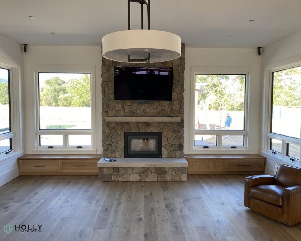 Central fireplace with large TV above and two large windows on each side.