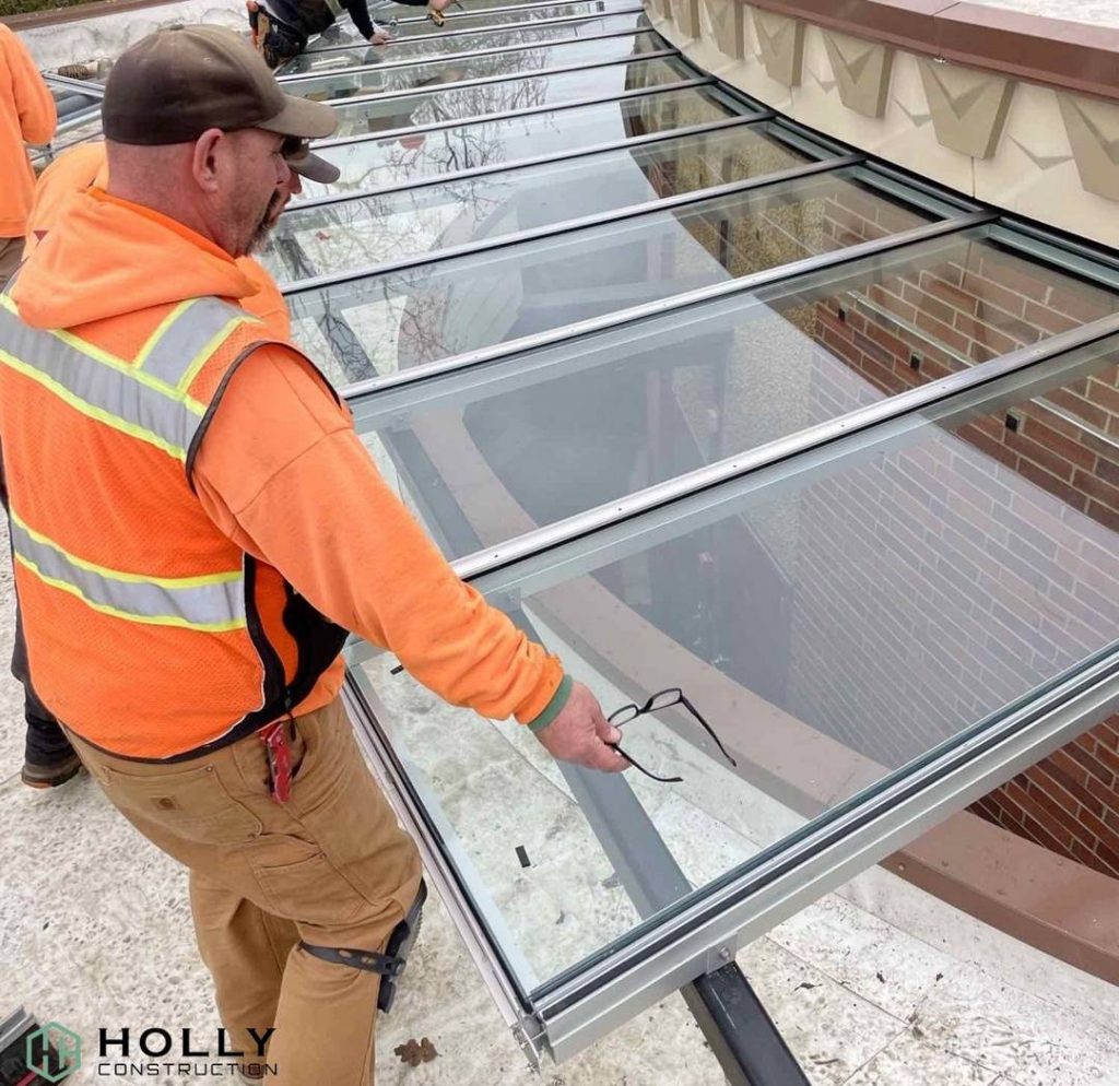 Man in High Visibility Jacket Holding Glass Frame.