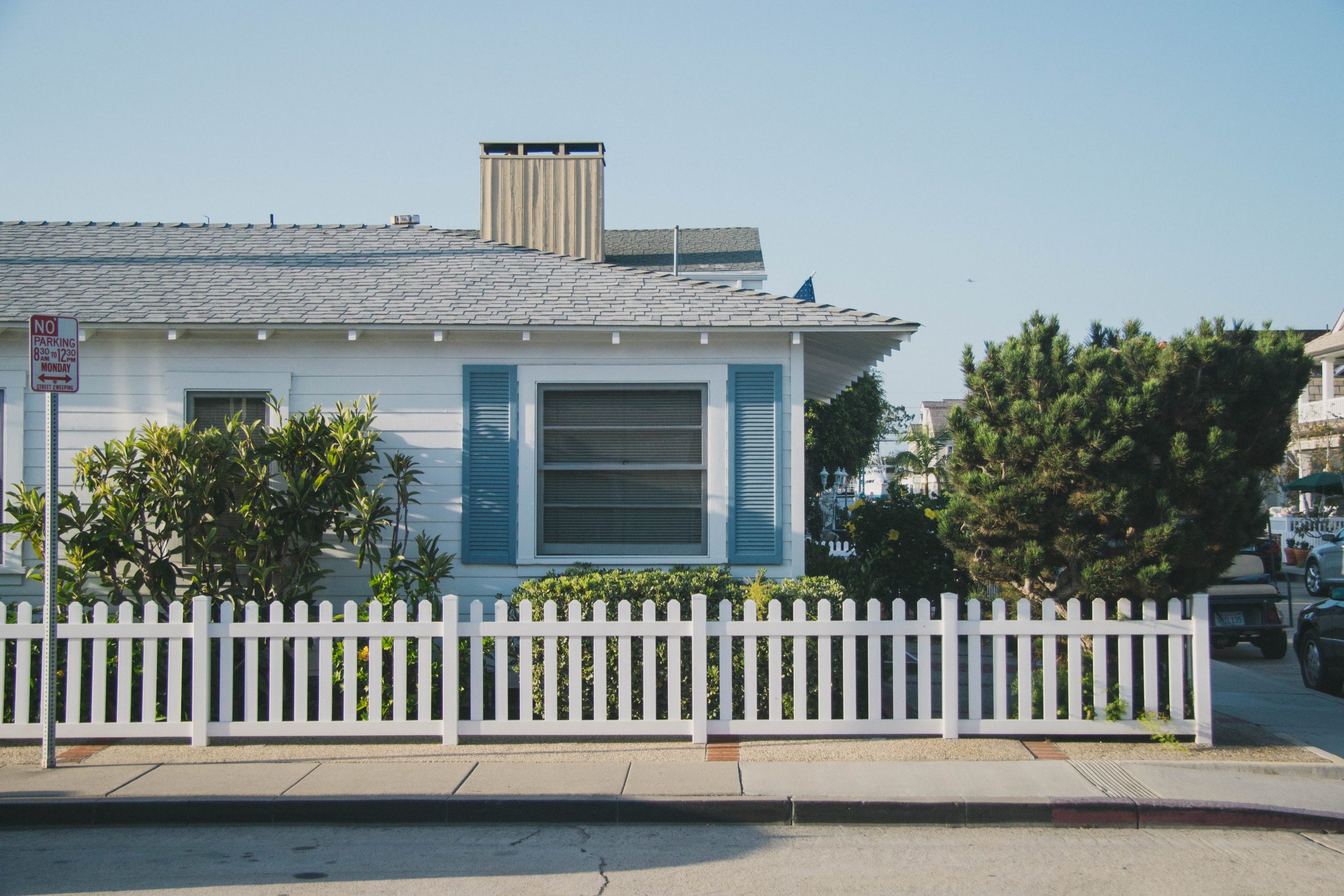 A white picket fence in front of a house.