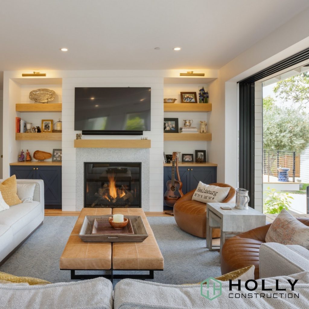 White room filled with furniture, fireplace and a large television on the wall