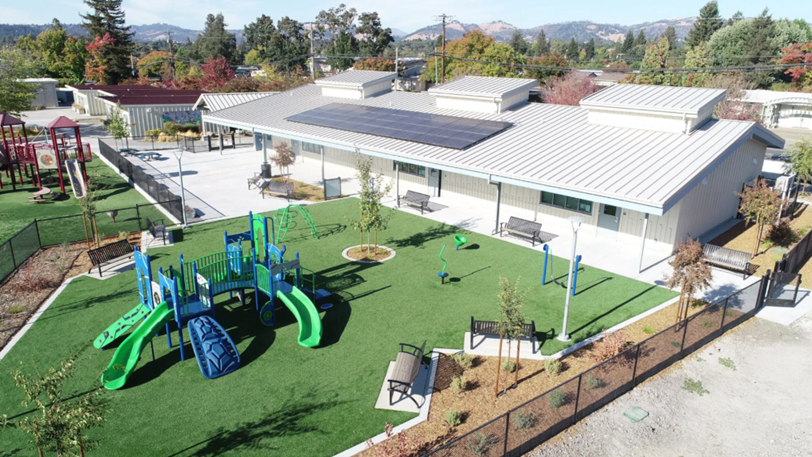 A newly constructed elementary school next to a children's playground.
