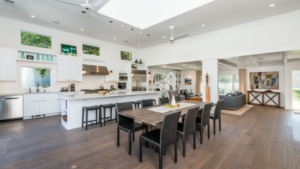 An open-concept kitchen and dining area with a large island and seating area with table.